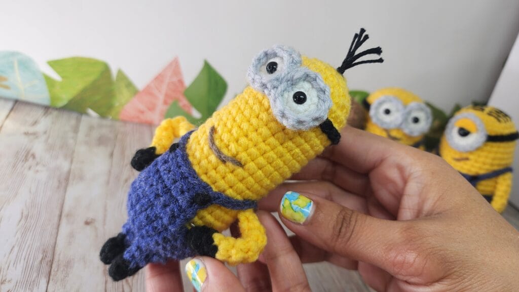 Kevin Minions Eng Amigurumi holding it, minions on background